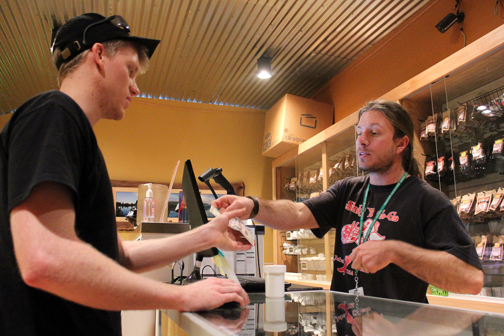 Justin Lapenter, right, a bud tender, gives Chris Horner, a Colorado State graduate who now lives in Niwot, change back after Lapenter bought his first legal weed at the Terrapin Care Station, Tuesday, Feb. 18, 2014, in Boulder, Colo. Recreational weed must be purchased with cash. The Terrapin Care Station, located at the corner of Folsom Street and Canyon Boulevard, was the first recreational pot shop to open in the city of Boulder. Karing Kind, a recreational pot shop north of Boulder, was the first to open in Boulder County. (Kai Casey/CU Independent)