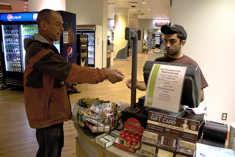 Sophomore economics major Dhruvin Patel helps a customer at the cash register at Alferd Packer Grill in the UMC on Tuesday, Feb. 18. (Matt Sisneros/CU Independent)