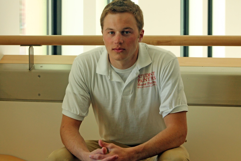 Sophomore communications major Brett Warner poses for a portrait in the Visual Arts Complex. Warner is a branch manager for Student Painters in Longmont, Colo. (Maddie Shumway/CU Independent)