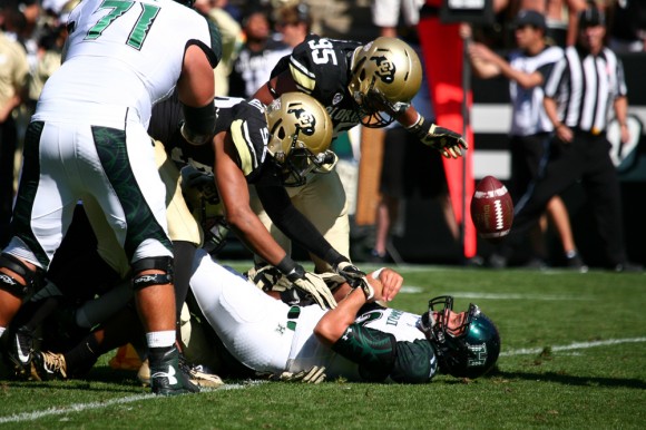 Hawaii senior quarterback Jeremy Higgins (12) loses the ball after being hit by Colorado's Jimmie Gilbert (98) and Derek McCartney (95) during an NCAA football game between the Colorado Buffaloes and the Hawaii Rainbow Warriors on Saturday at Folsom Field in Boulder, Colo. The Buffs won 21-12, getting their first home win of the season. The Buffs didn't give up a touchdown on Saturday, but they might have to play even better this week with Cal averaging 44 points per game. (Kai Casey/CU Independent)