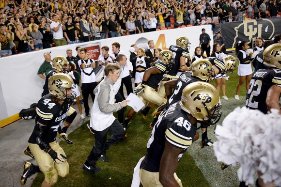 Head Coach Mike MacIntyre and the rest of the Colorado Buffaloes make their way onto the field to start the second half of the 2014 Rocky Mountain Showdown. On Saturday, the Buffs narrowly escaped Massachusetts with a 41-38 win. (James Bradbury/CU Independent)