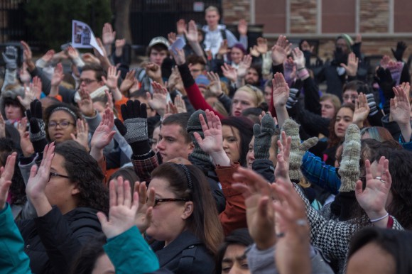 CU students and Boulder residents participate in a Ferguson protest with the "hands up, don't shoot" pose at the UMC fountain at 11am on Dec 1, 2014. (Matt Sisneros/CU Independent)