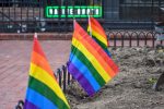 Pride flags placed in a garden on Pearl Street.