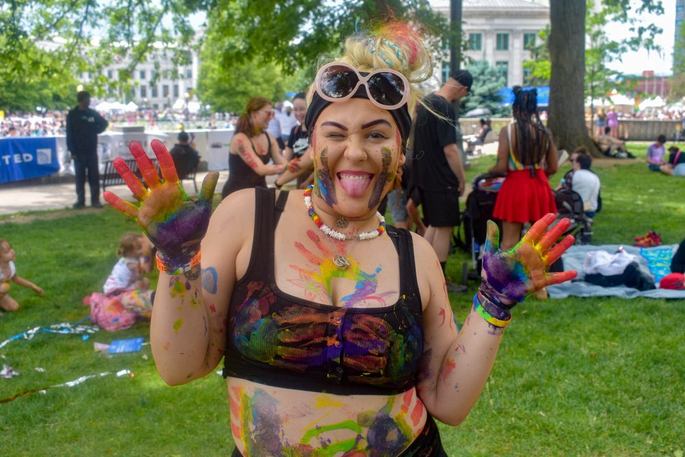 A Denver PrideFest attendee covered in rainbow paint.