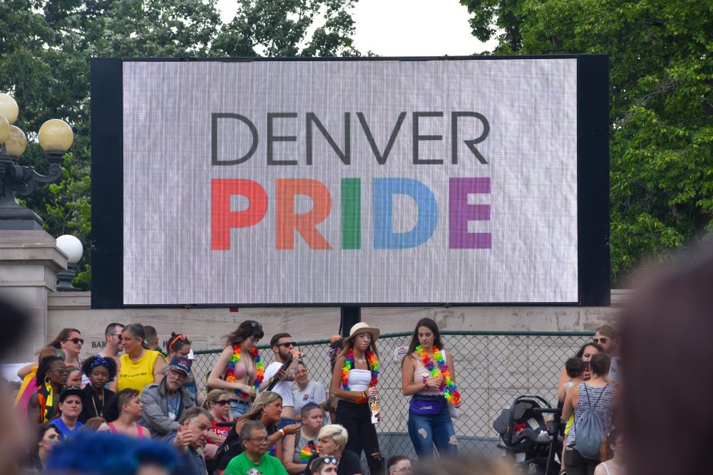 A screen displaying "Denver Pride" next to the center stage at Denver PrideFest.